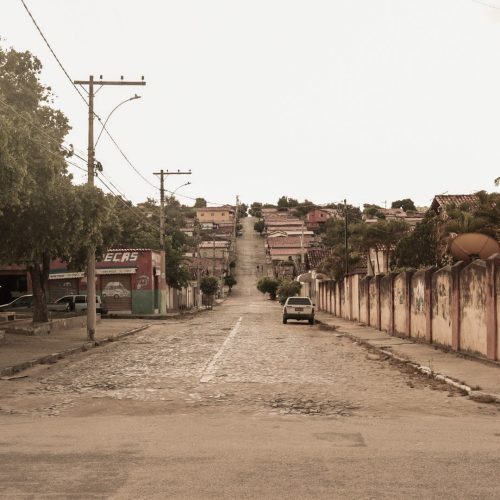 Fotografia de uma rua com morro com várias casas em Rubim.